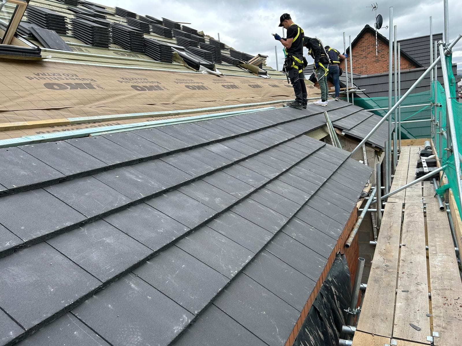 PipsPrice roofing team fitting new roof tiles from scaffolding