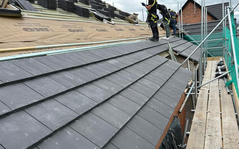 PipsPrice roofing team fitting new roof tiles from scaffolding